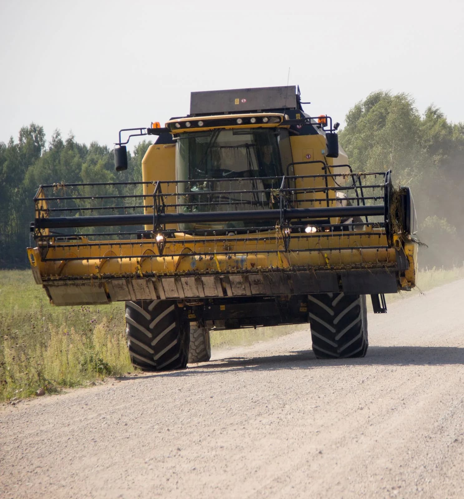 Moissonneuse-batteuse circulant sur un chemin rural en terre