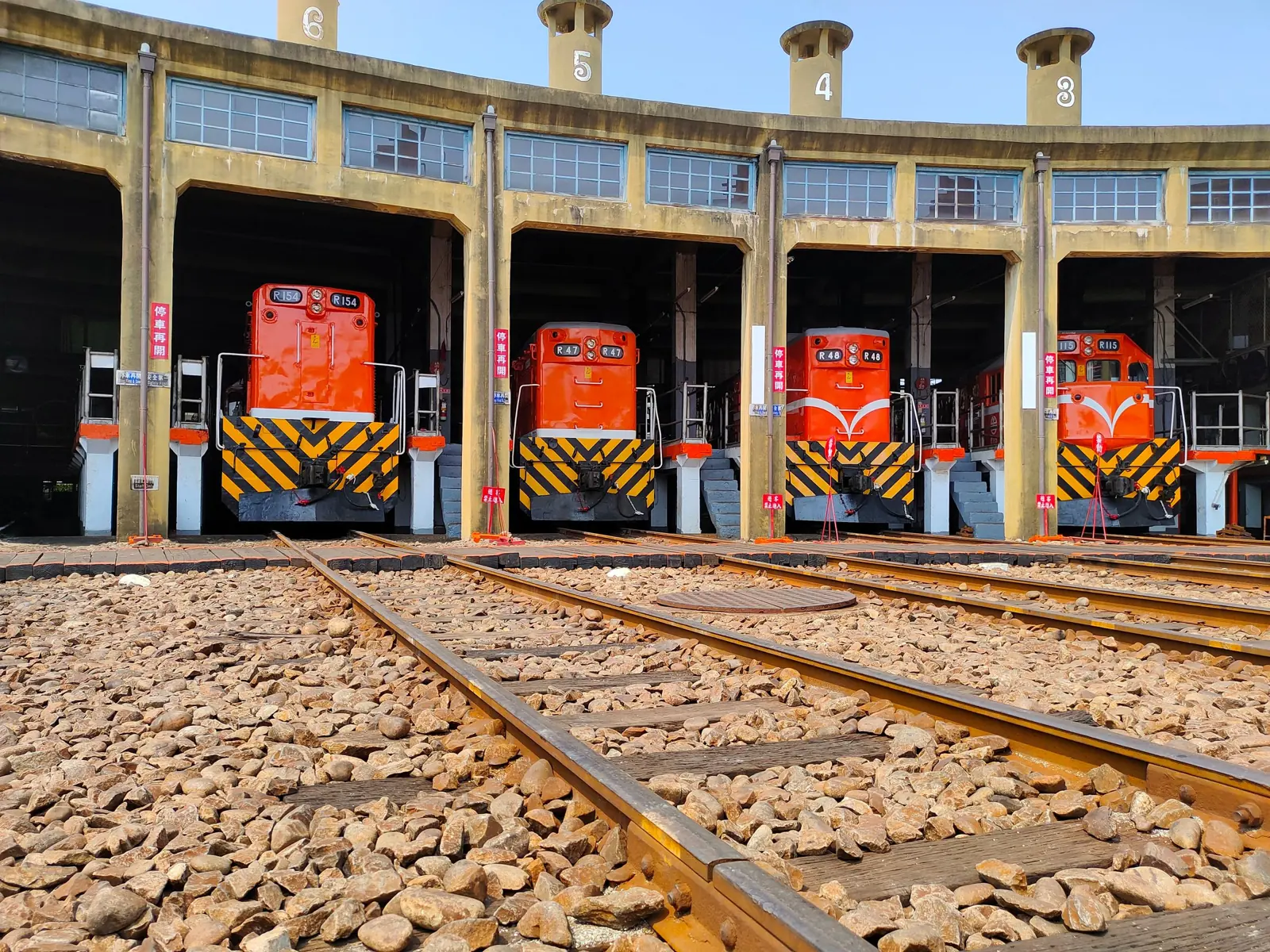 Diesel locomotives parked in a railway roundhouse depot