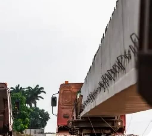 Grinzi prefabricate din beton încărcate pe camioane pentru transport greu